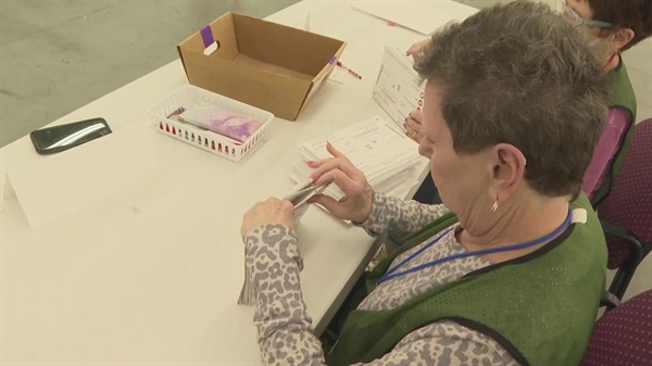 Election officials in Colorado's Arapahoe County show how their checks and...