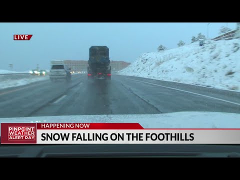 Snow falls along the foothills