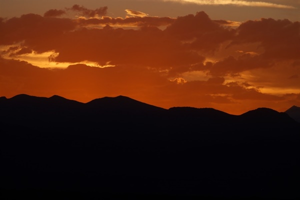 Does the sun set earlier in Denver because of the mountains?